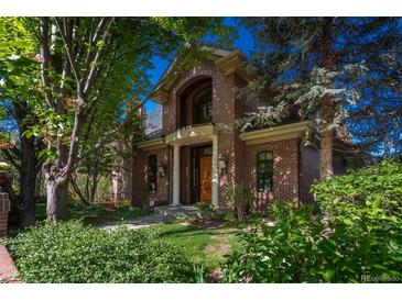 Beautiful brick home with manicured lawn and mature trees provides a cozy curb appeal at 465 Monroe St, Denver, CO 80206