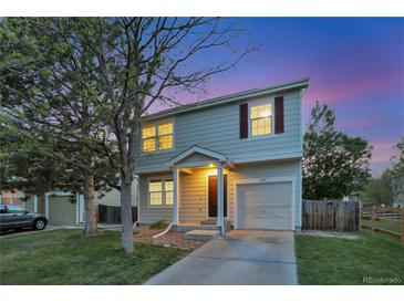 Charming two-story home with a one car garage, manicured lawn, and lovely dusk sky backdrop at 4347 W Kenyon Ave, Denver, CO 80236