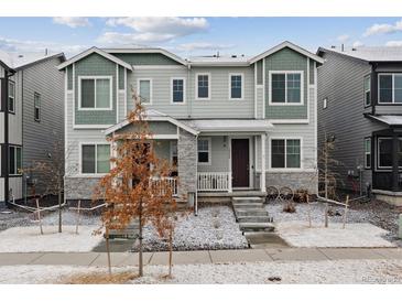 Charming two-story townhome with stylish gray exterior, stone accents, and a welcoming front porch at 18304 Caffey Dr, Parker, CO 80134