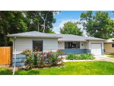 Charming ranch style home featuring a manicured lawn and flower beds at 3317 W Belmont Ave, Littleton, CO 80123