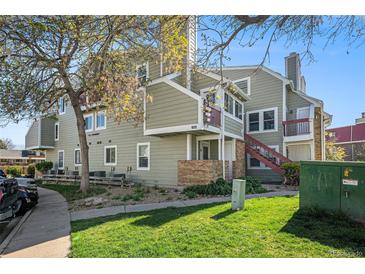 A lovely view of the apartments with lush grass, trees, and a clear, blue sky for a refreshing outdoor experience at 922 S Dearborn Way # 8, Aurora, CO 80012