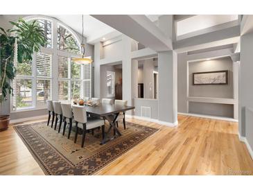 Bright dining room featuring large windows, wood floors, and a modern light fixture at 29432 Camelback Ln, Evergreen, CO 80439