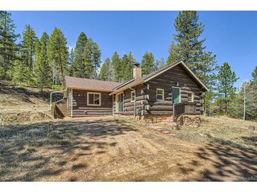 Charming log cabin home with a stone foundation, nestled among tall pine trees at 30570 Highway 72, Golden, CO 80403