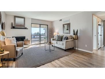 Cozy living room features a fireplace, balcony access, and neutral decor at 499 Wright St # 308, Lakewood, CO 80228