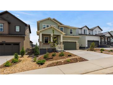 Charming two-story home featuring a manicured front yard and inviting covered porch at 8550 Cheraw St, Littleton, CO 80125