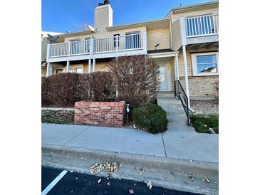 Tan two-story townhome with balcony and landscaping at 956 S Pitkin Ct, Aurora, CO 80017