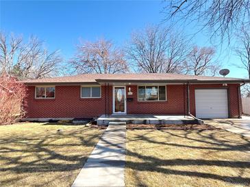 Charming brick home with a well-maintained lawn, walkway, and a single car garage at 6556 Wolff St, Arvada, CO 80003