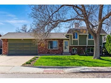 Charming home features brick and siding exterior, large driveway, and grassy front yard at 4581 S Garrison St, Littleton, CO 80123