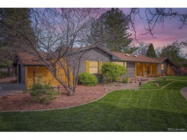Charming single-story home featuring a well-manicured lawn, mature trees, and unique rock landscaping at 4 Meadowlark Ln, Littleton, CO 80123