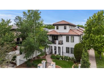 Stunning two-story home with a red tile roof, arched entry, balcony, and beautifully landscaped front yard at 579 Madison St, Denver, CO 80206
