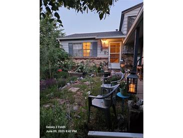 Charming home featuring a landscaped front yard with mature plants and inviting outdoor seating at 17232 E Oberlin Pl, Aurora, CO 80013