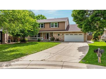 Charming two-story home featuring a well-manicured lawn, mature trees, and a long driveway at 12414 Clayton Way, Thornton, CO 80241