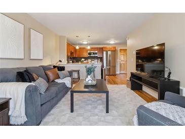 Inviting living room featuring a cozy couch, modern decor, and an open layout leading to the kitchen at 1410 York St # 35, Denver, CO 80206