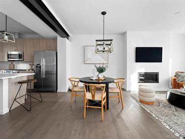 Modern living room featuring a fireplace, dining area, and open concept kitchen with stainless steel appliances at 8711 E Hampden Ave # 20, Denver, CO 80231