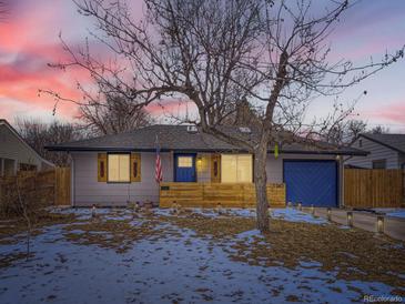 Charming single-Gathering home featuring a bright blue garage door, a covered entryway, and a manicured front yard at 1140 S Elm St, Denver, CO 80246