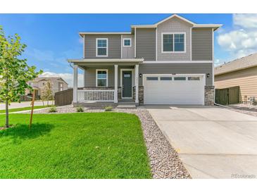 Charming two-story home with well-maintained lawn and two car garage at 9886 Ceylon Ct, Commerce City, CO 80022