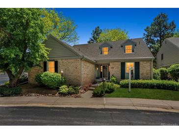 Charming brick home with dormer windows, mature trees, and inviting landscaping at 7190 S Poplar Ct, Centennial, CO 80112