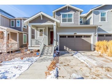 Charming two-story home with a covered front porch, two-car garage, and well-maintained yard at 17470 E 95Th Pl, Commerce City, CO 80022