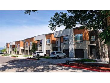 Modern townhomes boast stylish exteriors with a combination of gray brick, light beige stucco, and warm wood accents at 2879 W Parkside Pl, Denver, CO 80221