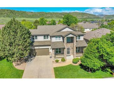 Beautiful two-story home boasts manicured lawn, lush landscaping and a stone facade entry at 8427 S Parfet Ct, Littleton, CO 80127