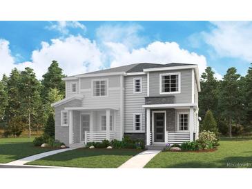 Charming townhome featuring stone accents, siding, a covered porch, and manicured landscaping in a desirable neighborhood at 1364 Penner Dr, Erie, CO 80026