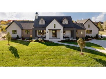 Stunning modern farmhouse exterior with white brick and a spacious lawn at 6816 Goldbranch Dr, Niwot, CO 80503