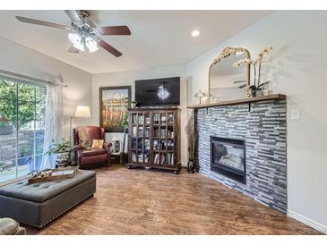 Cozy living room features a fireplace, hardwood floors, and access to a private patio at 8767 E Dry Creek Rd # 1312, Englewood, CO 80112