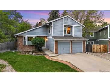 Charming two-story home with blue siding, brick accents, and a well-manicured lawn at 8940 W 80Th Dr, Arvada, CO 80005
