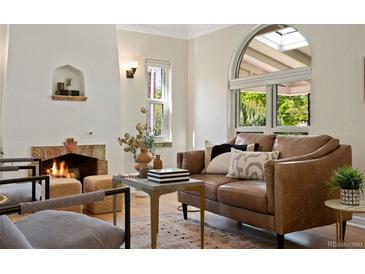Cozy living room with a fireplace, comfortable seating, and a large window at 1434 Clermont St, Denver, CO 80220