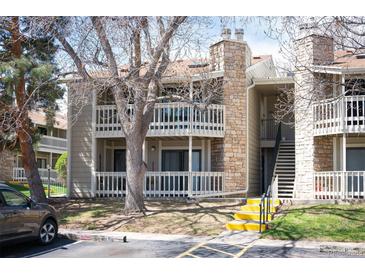 Two-story condo featuring balconies, stone accents, and stairs leading to upper units at 8225 Fairmount Dr # 10-204, Denver, CO 80247