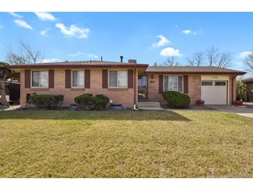 Charming brick home with manicured lawn and attached garage offers great curb appeal at 65 Reed St, Lakewood, CO 80226