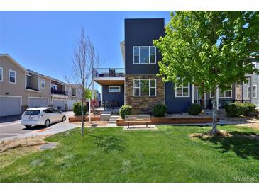 Beautiful modern home featuring a well manicured lawn, clean landscaping, and a porch balcony at 719 Robert St, Longmont, CO 80503