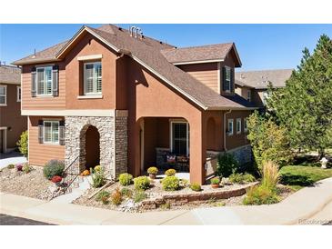 Inviting two-story home featuring a charming stone-accented entry and well-maintained landscaping at 10654 Ashfield St, Highlands Ranch, CO 80126