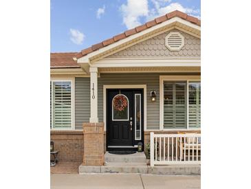 Charming home featuring a welcoming front door with decorative wreath and brick accents at 1410 Exquisite St, Castle Rock, CO 80109
