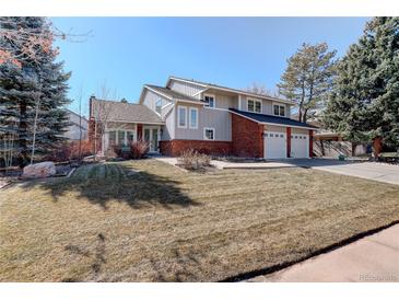 Charming two-story home with a brick and gray facade, mature trees, and a well-maintained lawn at 9526 E Lake Ave, Greenwood Village, CO 80111