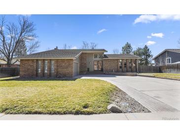 Well-maintained, single-story home featuring a brick facade and an expansive, paved driveway at 6866 W David Ave, Littleton, CO 80128