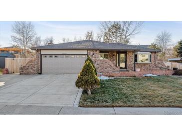 Charming brick home featuring a well-maintained lawn and a two-car garage at 13215 Peacock Dr, Lone Tree, CO 80124