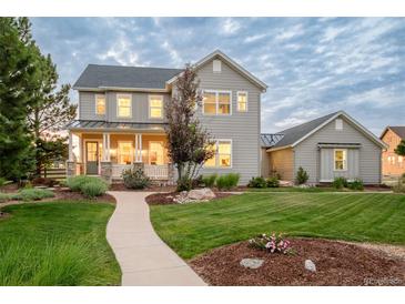 Charming two-story home featuring a landscaped yard, covered porch, and neutral gray siding under a cloudy sky at 5397 Lenox Ct, Castle Rock, CO 80104