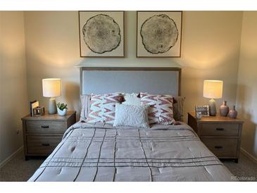 Cozy bedroom featuring stylish decor, bedside tables with lamps, and inviting neutral color palette at 8625 W Dartmouth Pl, Lakewood, CO 80227