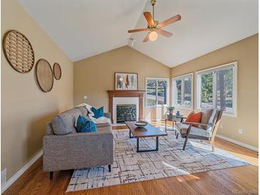Cozy living room with vaulted ceilings, fireplace, natural light and modern furnishings at 4228 Scenic Village Dr, Evergreen, CO 80439