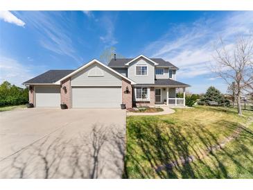 Charming two-story home featuring a spacious three-car garage and well-maintained front yard at 29145 E 160Th Ct, Brighton, CO 80603