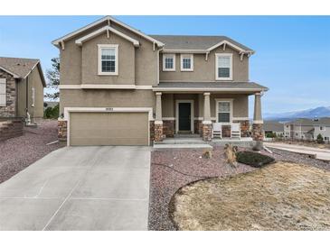 Charming two-story home with a well-manicured front yard, covered porch, and an attached two-car garage at 19703 Serenity Springs Pt, Monument, CO 80132