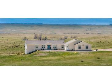 Charming ranch-style home with a sprawling lawn and mountain views at 5129 S Tom Bay Rd, Bennett, CO 80102