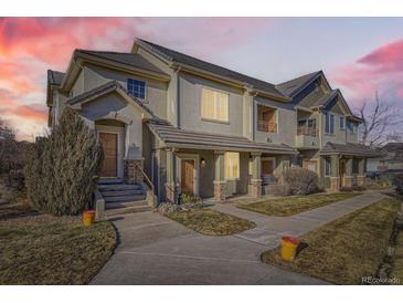 Charming townhouse featuring a stucco facade, tiled roof, and inviting front entrance with stone accents at 22520 E Ontario Dr # 101, Aurora, CO 80016