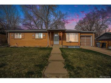 Charming brick home with a well-maintained lawn and attached garage at 3937 W Grand Ave, Littleton, CO 80123