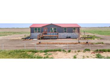 Charming single-story home featuring a red roof, welcoming front porch, and well-maintained landscaping at 41575 E 88Th Ave, Bennett, CO 80102