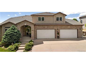Elegant two-story home featuring a brick and stucco facade, well-manicured landscaping, and a spacious two-car garage at 2595 S Harlan Ct, Lakewood, CO 80227