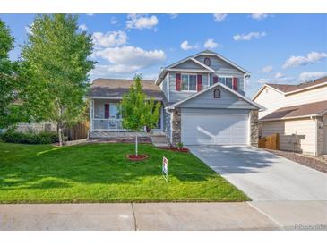 Charming two-story home with well-manicured lawn, inviting front porch, and attached two-car garage at 23634 Broadmoor Dr, Parker, CO 80138