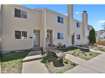 Charming townhome exterior with a cozy entrance and well-maintained beige siding under a clear blue sky at 1287 Benton St, Lakewood, CO 80214