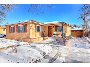 Brick ranch home with a snow-covered front yard, driveway, and attached garage at 3126 S Franklin St, Englewood, CO 80113